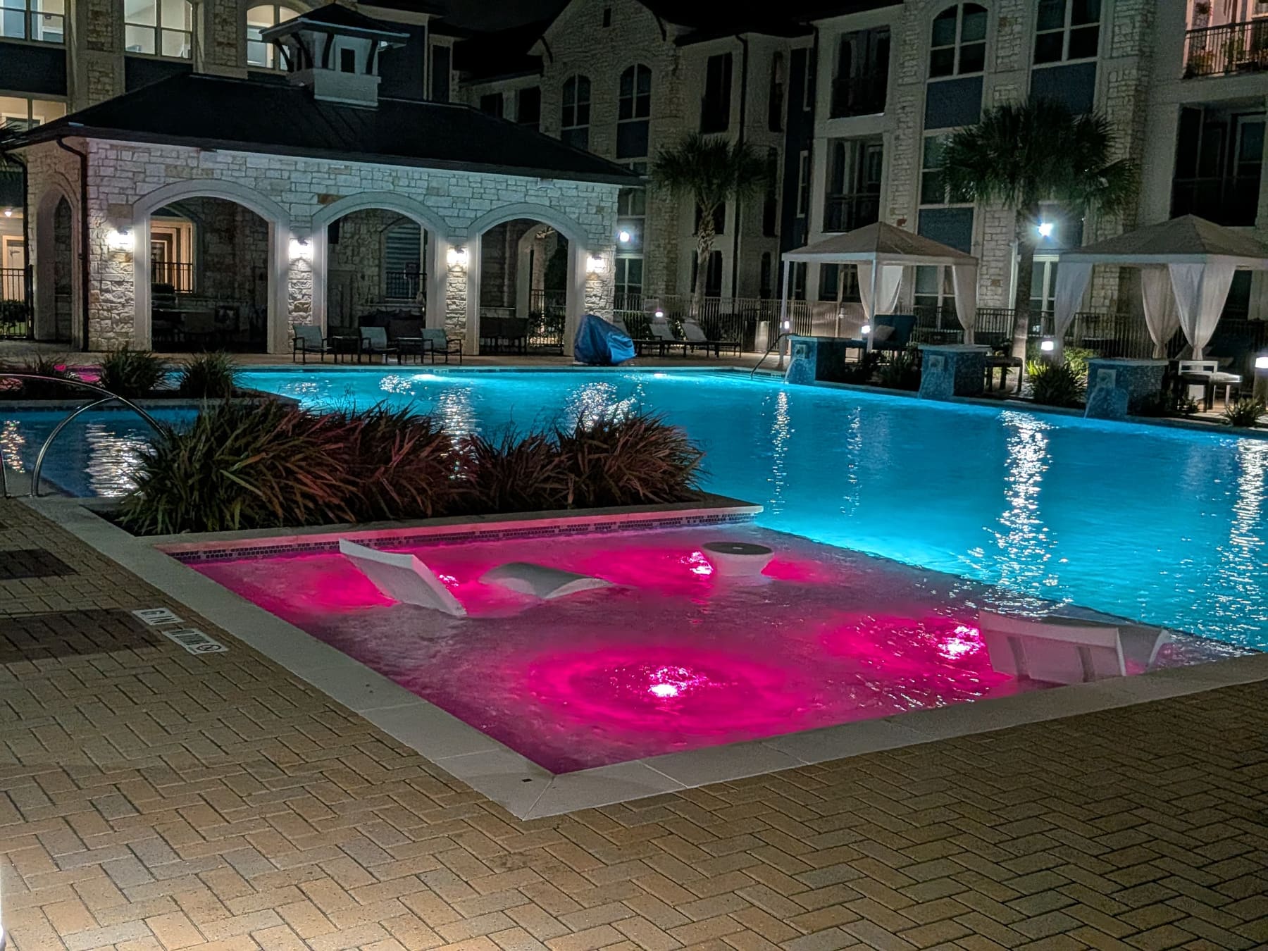 Community pool tanning ledge with color-changing lights